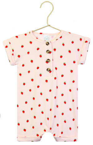 A pink Baby Girls’ Junie Romper one-piece by Lou Lou & Company for babies, featuring short sleeves, wooden buttons, and a small red strawberry pattern, displayed on a gold hanger against a white background.