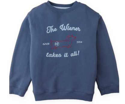 The Boys’ Riccardo Pullover by Gingersnaps is a blue fleece sweatshirt, detailed with a snug and stylish red embroidered outline of a dachshund and the phrase “The Wiener takes it all! since 1994” on the front.