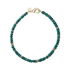 From the Jane Win Gumdrop Beaded Necklace Collection: a beaded necklace with dark green beads, gold spacer rings, a gold clasp, and a round gold tag—style it with a Jane Win pendant for a chic statement.
