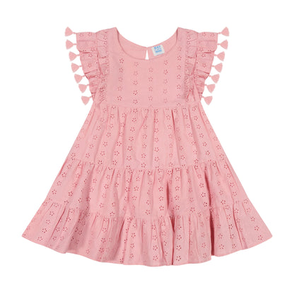 The Girls’ Sophie Tassel Dress by Mer is a pink, short-sleeved dress for girls made from lightweight cotton, featuring tiered layers with eyelet details and flutter sleeves accented by playful tassels, shown laid flat on a white background.