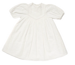 The Girls’ Beth Dress by Early Sunday is a white vintage-style cotton dress featuring delicate embroidery, puffed short sleeves, a high neckline, and subtle decorative trim. Displayed flat against a white background, this charming ivory dress evokes classic elegance and is perfect for special occasions.