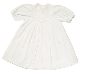 The Girls’ Beth Dress by Early Sunday is a white vintage-style cotton dress featuring delicate embroidery, puffed short sleeves, a high neckline, and subtle decorative trim. Displayed flat against a white background, this charming ivory dress evokes classic elegance and is perfect for special occasions.