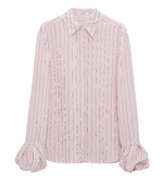 The Striped Ease Blouse by Dorothee Schumacher is a long-sleeve button-up in pink and white organdy voile, featuring vertical stripes, flared cuffs, and a pointed collar.