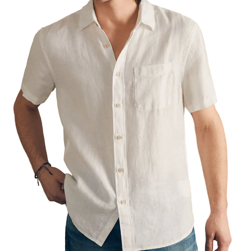 A person wears the Faherty Short-Sleeve Palma Linen Shirt—a white, button-up linen shirt with a chest pocket—paired with blue jeans, creating a perfect summer look against a white background.