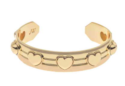 The Jane Win Love Set in Stone Heart Cuff features raised heart motifs and parallel line detailing, inspired by Jane Win coins, with an engraved "JW" on the inner side.