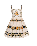 The Lima Mini Dress by Agua By Agua Bendita is a sleeveless, knee-length cotton mini with a fitted bodice, A-line silhouette, orange fruit and floral prints, and navy blue ribbon accents.