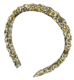 The Liberty Print Braid Headband by Tartine et Chocolat features a fabric-covered design with a scalloped edge and showcases a green, yellow, and purple floral pattern on a white background.