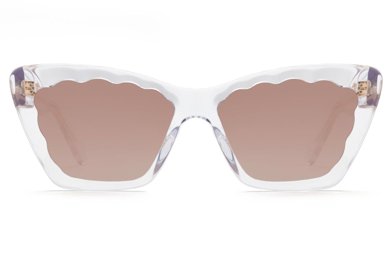 Front view of Krewe Brigitte Sunglasses showcasing a clear frame with wavy edges around the brown-tinted lenses and a stylish cat-eye silhouette.