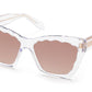 Krewe Brigitte Sunglasses by Krewe are clear-framed luxury eyewear with pink-tinted lenses, a scalloped edge design, and a chic cat-eye silhouette, offering full UVA/UVB protection.