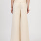 Back view of a person wearing Simkhai's Leroy Pleated Wide Leg Pant in cream, paired with a matching fitted top, standing against a plain white background.