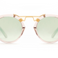 Krewe St Louis Mirrored Sunglasses by Krewe feature round, luxury acetate frames with light green lenses, a 24K gold plated bridge, and transparent rims. Enjoy UVA/UVB protection while exuding sophistication.