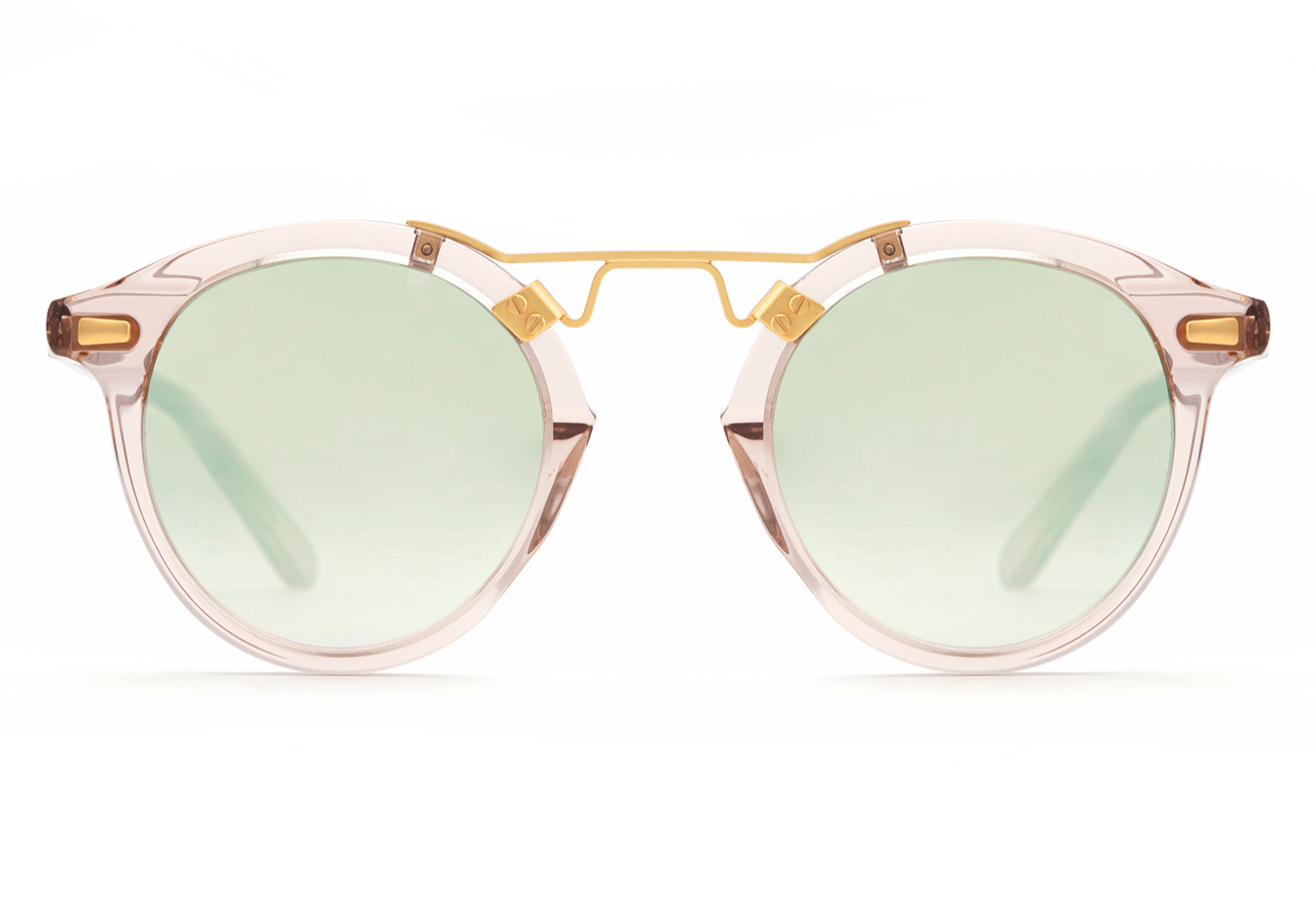 Krewe St Louis Mirrored Sunglasses by Krewe feature round, luxury acetate frames with light green lenses, a 24K gold plated bridge, and transparent rims. Enjoy UVA/UVB protection while exuding sophistication.