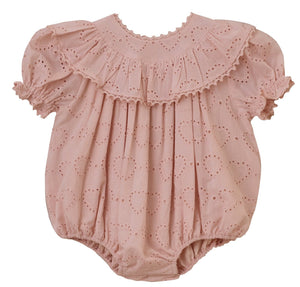 The Noralee Eva Romper, a charming pink outfit by Noralee, boasts a frill collar and sleeves. It's crafted from heart eyelet fabric for a delightful pattern design.