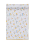 Duck Pond Paddles Blanket by Kissy Kissy, made from soft Pima cotton, showcases a delightful pattern of ducks and is neatly rolled at the top with delicate yellow trim along the edge.