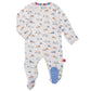 The Magnetic Me Baby Boys' Footie is a white onesie adorned with small cartoon vehicles and machinery in blue, orange, and turquoise. Made from eco-friendly TENCEL™ modal with temperature-regulating properties, it features closed feet with one foot sporting a blue patch and a collar with rainbow stripes.
