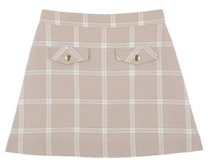 Girls’ Perrin Pocket Flannel Skirt by The Beaufort Bonnet Company, showcasing a beige A-line silhouette with a white Thompson Park Plaid pattern, two front flap pockets, and elegant gold button details.