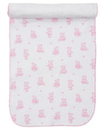 A white Pima cotton baby blanket with pink teddy bears, flowers, and pink scalloped trim, partially rolled at the top. Coordinates perfectly with Kissy Kissy’s Teddy Bear Time Burp Cloth for a charming matching set.