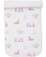 The Kissy Kissy Fairway Foursome Printed Burp Cloth, made from soft white Pima cotton, features charming pink scalloped edges and playful golf-themed patterns with golf carts, clubs, flags, and putting greens. Perfect for any little golf enthusiast.