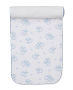 The Kissy Kissy Sweet Sheep Burp Cloth features white Pima cotton adorned with blue sheep and grass patterns, scalloped blue edging, and a rolled end—a soft and cozy essential inspired by classic designs.