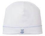 The Kissy Kissy Teddy Bear Time Hat with Hand Emb is a white Pima cotton baby hat with a blue hand-embroidered teddy bear and light blue stitched border, from our delightful Teddy Bear Collection.