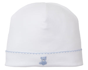 The Kissy Kissy Teddy Bear Time Hat with Hand Emb is a white Pima cotton baby hat with a blue hand-embroidered teddy bear and light blue stitched border, from our delightful Teddy Bear Collection.