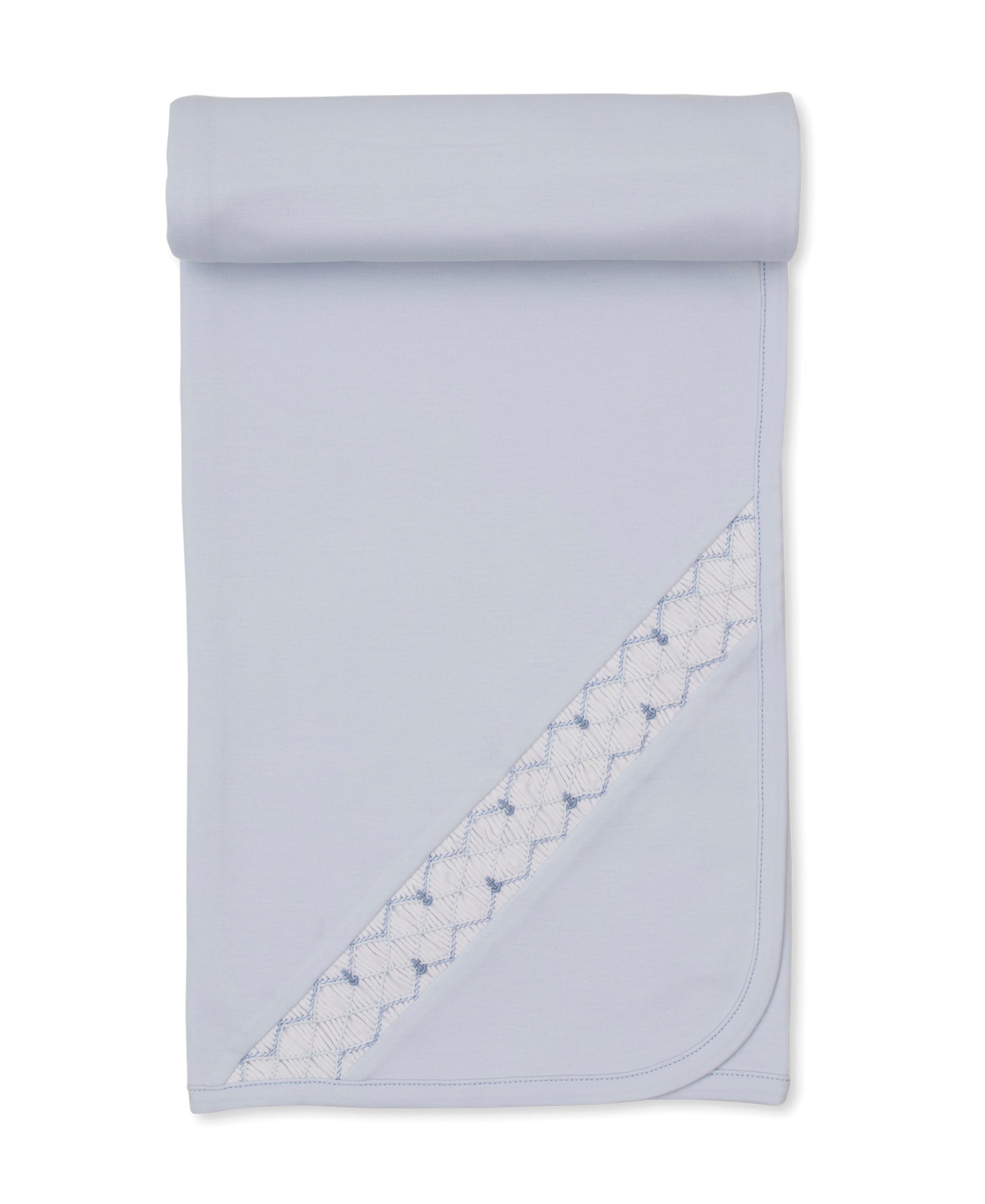 Hand Smocked Blanket by Kissy Kissy in light blue Pima cotton, featuring decorative stitched trim, shown partially unrolled on a white background.