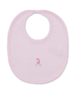 The SCE Safari Party Hand Striped Bib by Kissy Kissy is a light pink Pima cotton baby bib with a small embroidered pink giraffe in the center and features a convenient neck snap closure at the top.