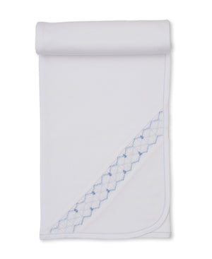 Wrap your little one in comfort and style with the Kissy Kissy Hand Smocked Blanket, crafted from soft white Pima cotton. Featuring a rolled top edge, delicate blue stitched border, and a diagonal section adorned with blue diamond embroidery, this blanket is both elegant and cozy.