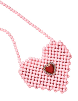 Pair a pink beaded necklace with a heart-shaped pendant featuring a red gem and clear stones with the Super Smalls Heartfelt Sparkle Pearl Handbag for a coordinated and charming pink-themed look.