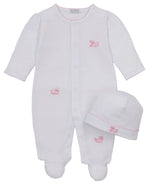 The Kissy Kissy Baby Puppy Paws Footie & Hat Set, crafted from soft Pima cotton, features a white infant sleeper adorned with pink stitched animal details and comes with a matching beanie hat, all displayed on a plain background.