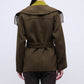 A person is shown from the back against a plain background wearing the Simkhai Rowen Fringe Jacket, a Western-inspired olive green coat featuring a belted waist, wide collar, and fringe detailing.