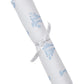 The Kissy Kissy Giraffe Grace Burp Cloth features white Pima cotton with blue giraffe prints and scalloped edges, rolled and tied with a white ribbon.