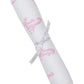 The Kissy Kissy Giraffe Grace Burp Cloth is a white Pima cotton burp cloth featuring pink giraffe prints, rolled and tied with a white ribbon printed with gray text.