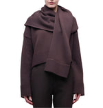 A person wears the Simkhai Elson Scarf Sweater—dark brown with a matching attached scarf, ribbed cuffs, and hem—standing against a plain white background.
