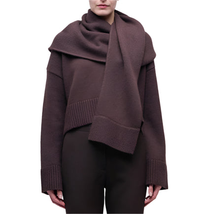 A person wears the Simkhai Elson Scarf Sweater—dark brown with a matching attached scarf, ribbed cuffs, and hem—standing against a plain white background.