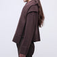A woman with long brown hair, seen from the side, wears the Simkhai Elson Scarf Sweater and matching brown pants against a plain light background.