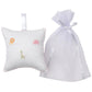 The Kissy Kissy Safari Wild Musical Pillow, a white Pima cotton square embroidered with a lion, elephant, and giraffe, comes in a sheer tulle gift bag—an adorable baby gift.