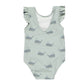 The Rylee & Cru Baby Girls' & Girls' Scoop Back Onepiece is a light green swimsuit with ruffled sleeves, a playful blue whale pattern, and UPF 50+ sun protection.