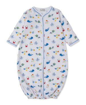The Kissy Kissy Baby Ocean Antics Convertible Gown is made of white Pima cotton and features long sleeves, blue trim, and a colorful ocean-themed print with whales, crabs, turtles, and sea stars.