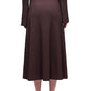 A person wearing Simkhai's Chiara Midi Skirt and a matching long-sleeve ribbed brown top, seen from the back with brown heeled shoes.
