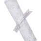 The Cheerful Good Night Printed Blanket by Kissy Kissy is a cozy, rolled-up white baby blanket in soft Pima cotton with gray moon, star, and cloud prints, tied with a "Kissy Kissy" ribbon.