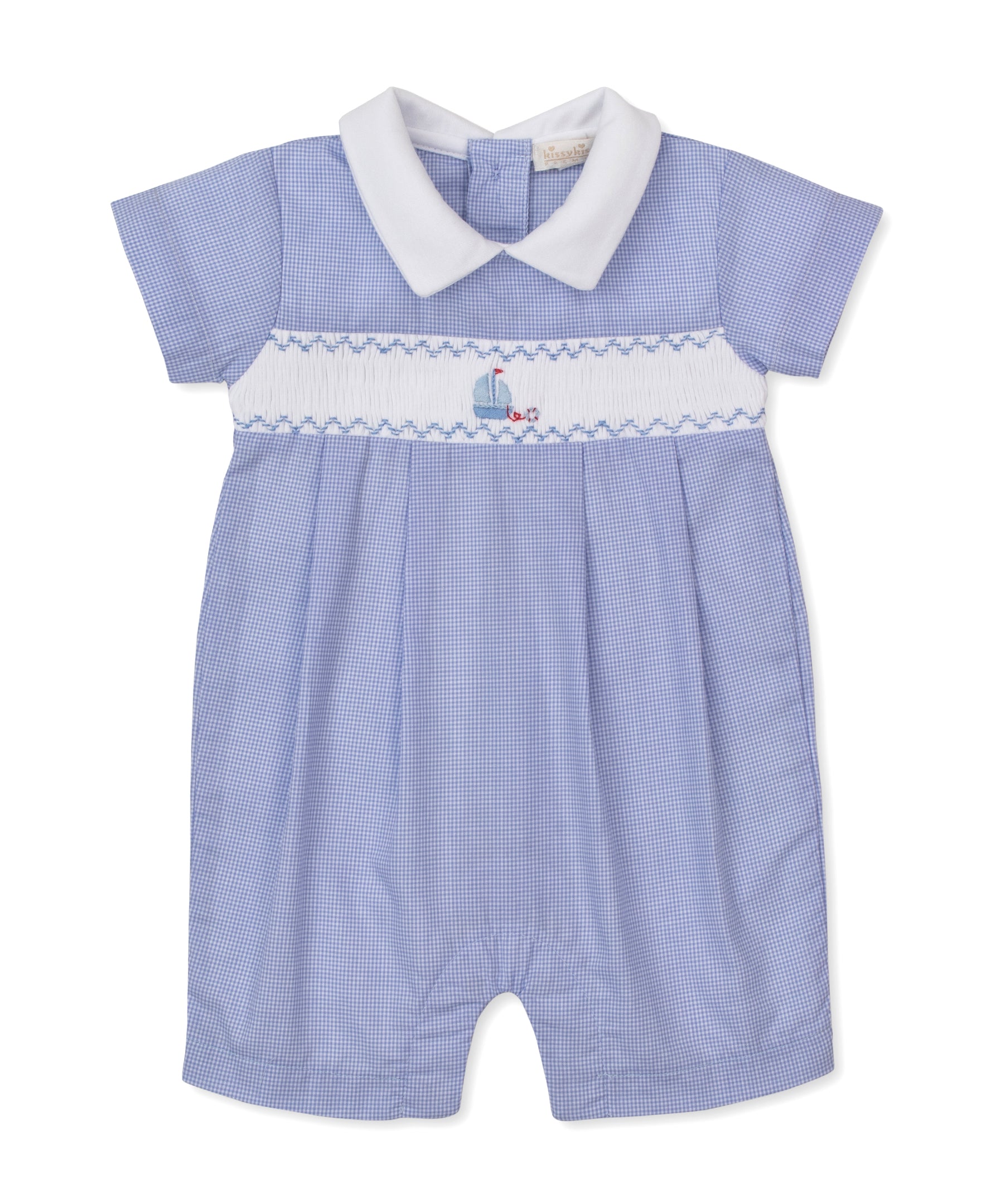 The Kissy Kissy Baby Boys' CLB Summer Medley Short Playsuit features a light blue gingham design with short sleeves, a white Peter Pan collar, and a white smocked panel across the chest adorned with charming sailboat embroidery. Crafted from soft Pima cotton for ultimate comfort.