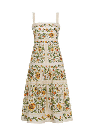 The Nispero Dress by Agua By Aguabendita is a sleeveless pure linen midi dress with wide straps, a square neckline, and a yellow and green floral print.