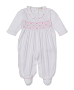 The Kissy Kissy Baby Girls’ Bows Footie is a white, long-sleeve Pima cotton footie featuring delicate pink smocking and trim, back buttons, and a ruffled collar for a cozy touch.