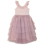 The Girls’ Pixie Dress by Noralee is a sleeveless, light pink dress featuring a luxurious velvet bodice, a ruffled neckline, and a tiered tulle skirt, displayed against a white background.