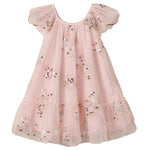 The Noralee Girls’ Edie Dress showcases a light pink hue with short sleeves, a flared skirt, and a gathered neckline. Sparkling sequins and embroidered star patterns adorn the tulle sleeves and lower skirt, while sheer fabric accents create an enchanting finish.