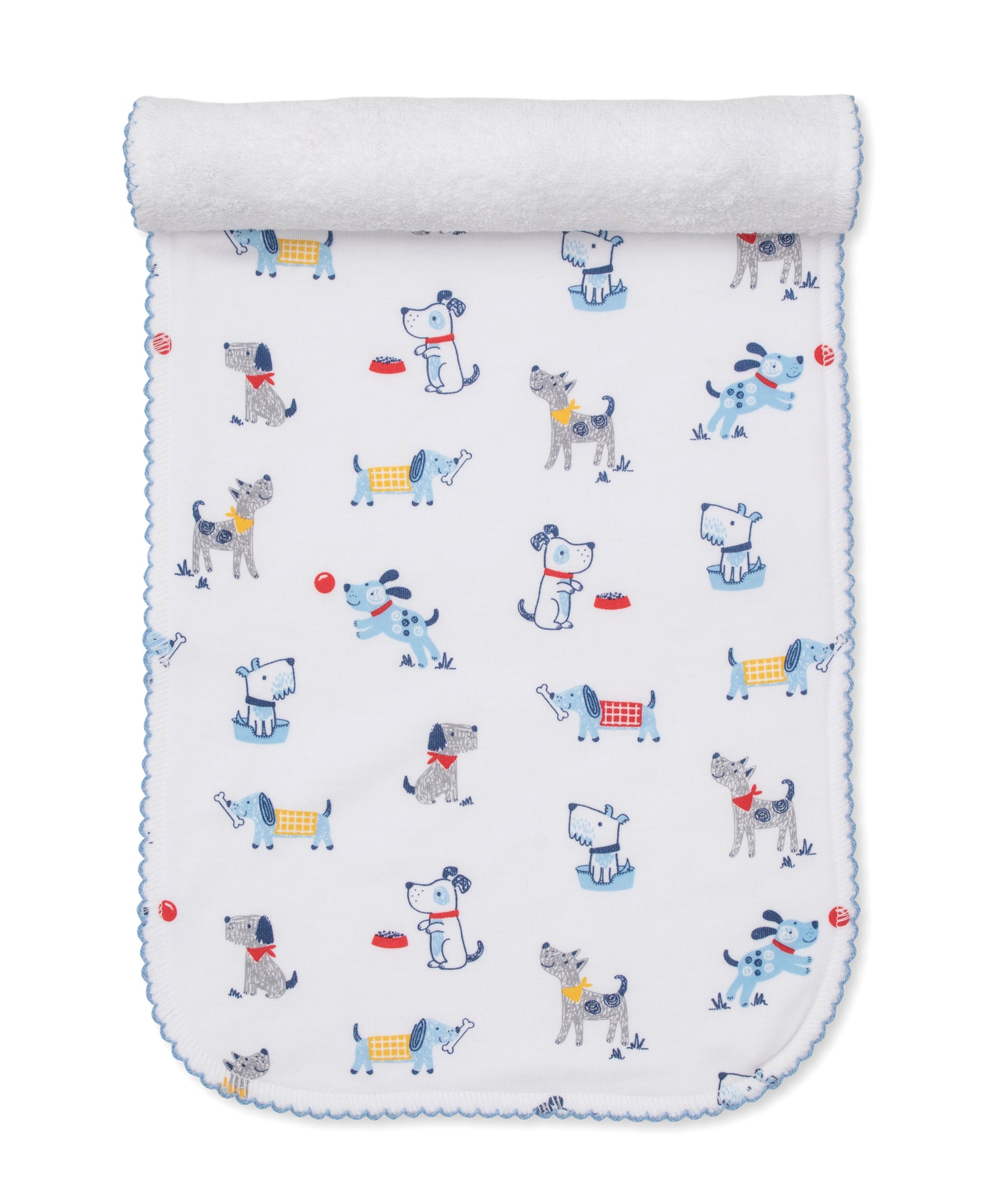 A white baby blanket with blue trim features a playful pattern of cartoon dogs in different poses—some wearing colorful collars or vests—alongside red balls and food bowls, creating an adorable design that perfectly coordinates with our Kissy Kissy Puppy Patch Burp Cloth for a cohesive nursery theme.