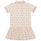 The Minnow Girls' Summer Cherries French Terry Drop Waist Tennis Dress features a cream color, short sleeves, collar, gathered skirt, and a red cherry and green leaf print, shown from the back.