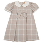 The Beaufort Bonnet Company’s Baby Girls’ and Girls’ Francene Frock is a charming, short-sleeved beige Thompson Park Plaid dress featuring a white Peter Pan collar, front bow detail, and pleated skirt—perfectly designed for young children.