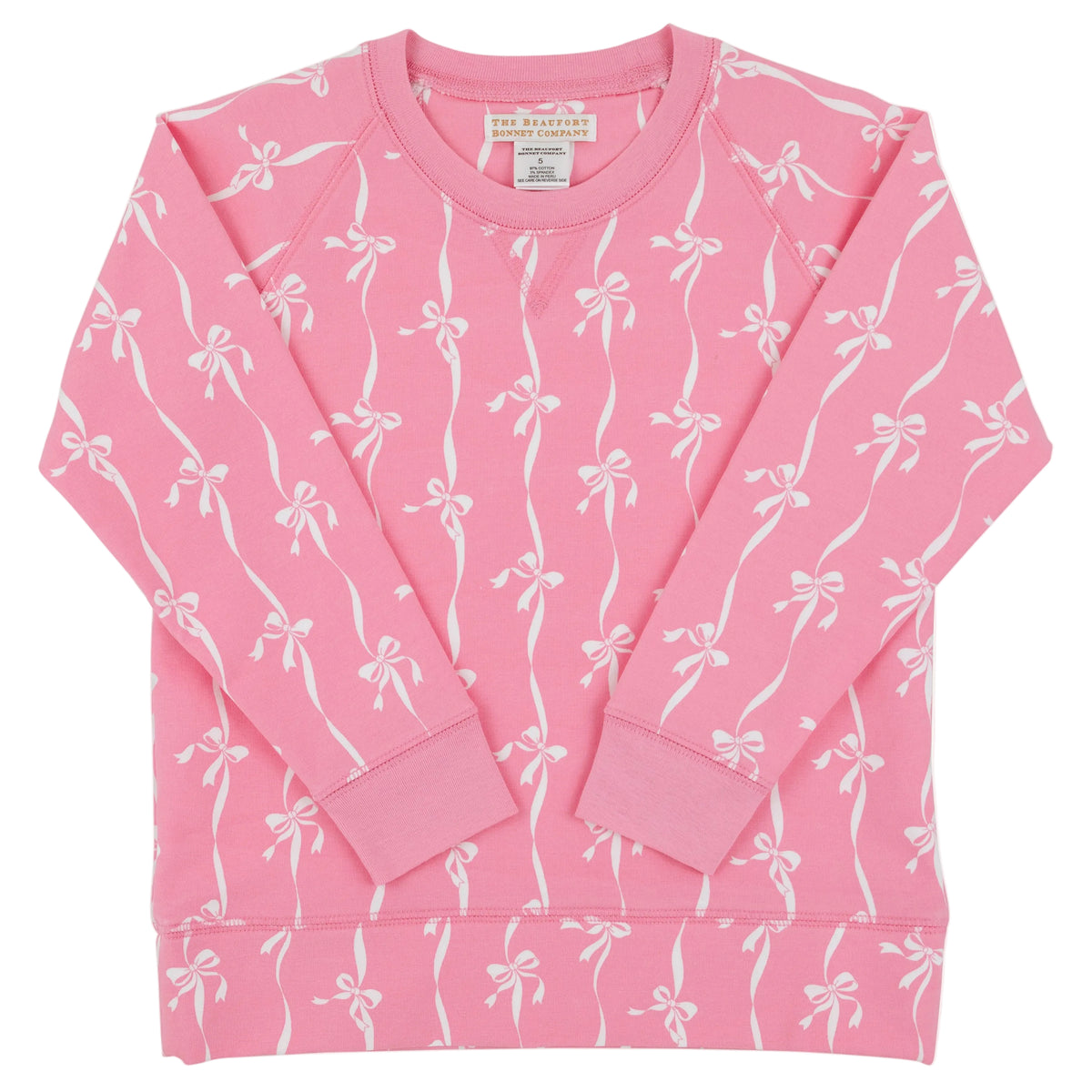 Baby Girls’ and Girls’ French Terry Cassidy Comfy Crewneck from The Beaufort Bonnet Company, shown in pink with a delightful Bow Print pattern of white bows and ribbons, displayed flat with the long sleeves crossed over the front.